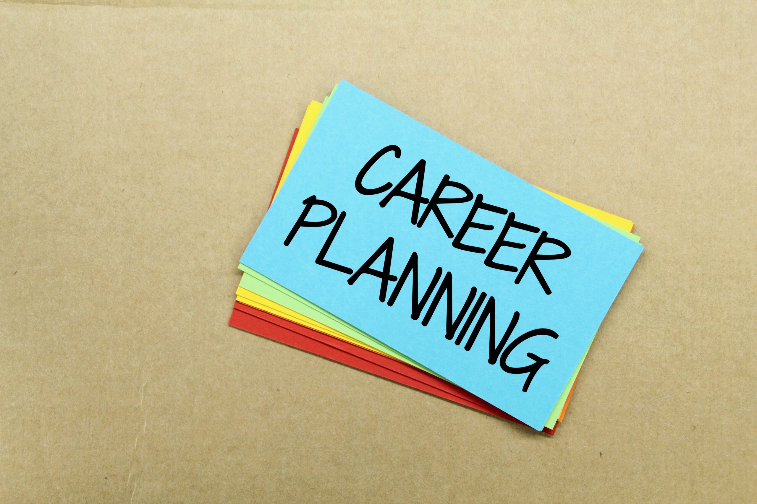 A stack of colorful notes sits, with the words "Career Planning" written in dark ink on the top blue note.